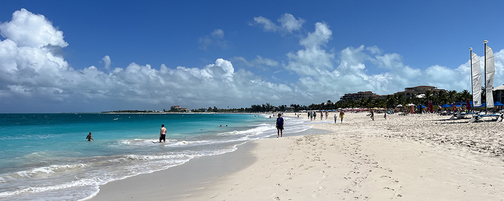 Photo of a white sandy beach with people walking and in the sea, and with coastal development in the background. Copyright: Jane Hawkridge JNCC.