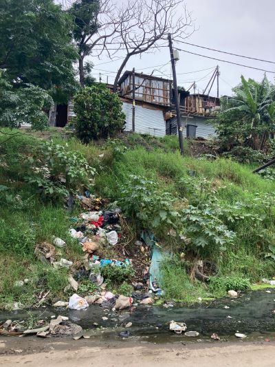 Photograph of an informal settlement on a hill with waste in the foreground (© Elizabeth Atkinson, Defra)