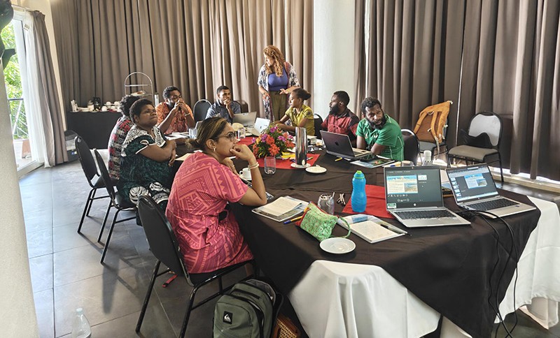 People sitting around a large table in a training workshop