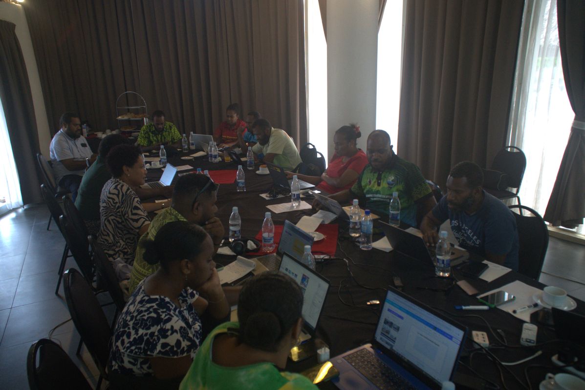 People sat around a large table working on laptops