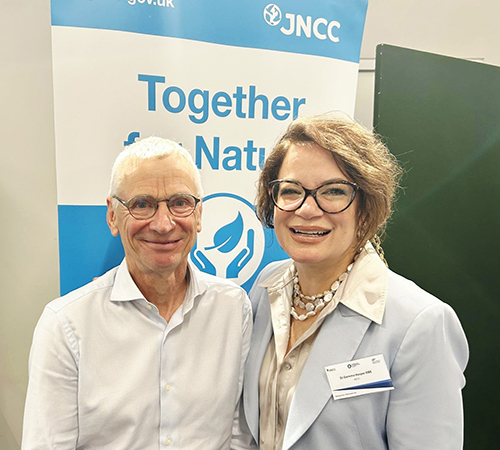 Photograph of David Cooper and Gemma Harper standing side by side and smiling at the camera